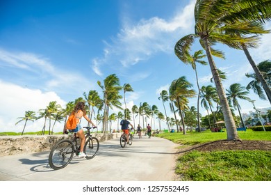 MIAMI - SEPTEMBER, 2018: Visitors and locals ride bicycles along the beachfront promenade in Lummus Park adjacent to historic Ocean Drive.