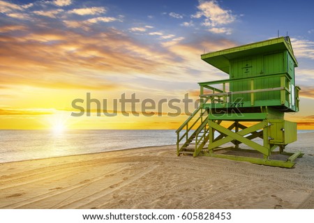 Miami South Beach sunrise with lifeguard tower and coastline with colorful cloud and blue sky. 