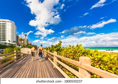 Miami, United States - October 06 2011 :two Surfers With Surf Boards Walk Bare Feet On The Board Walk Next To The Beach