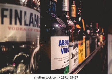Miami, USA - 2022: Closeup Of Bar Shelf With Bottles Of Absolut Vodka, Finland Vodka And Tequila Jose Cuervo