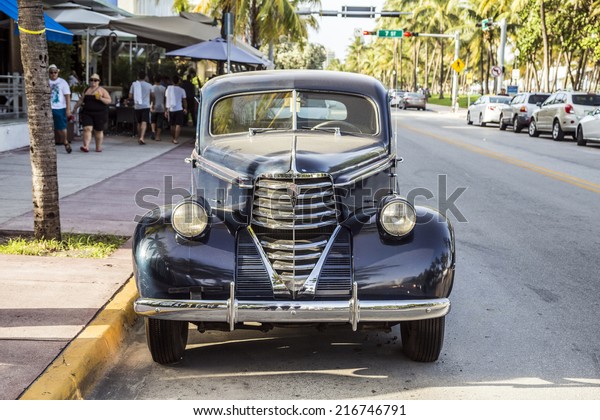 MIAMI, USA - AUG\
19, 2014: classic Oldsmobile parks in front of the Hotel Park\
Central in Miami, USA. Built in 1937, The Park Central is known as\
The Blue Jewel of Ocean\
Drive.