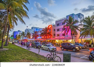 MIAMI, USA - AUG 23, 2014: people enjoy Palm trees and art deco hotels at Ocean Drive by night. The road is the main thoroughfare through South Beach in Miami, USA.