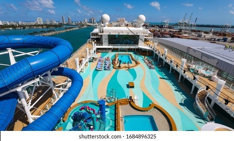 Miami, USA - March 20, 2020 - Top View Of Pool Side Area Of A Cruise Ship With Water Slides, Swimming Pool And Big Led Wall. 