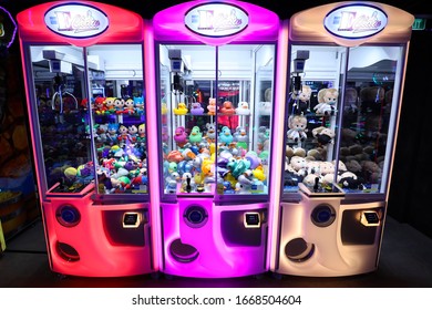 Miami, USA - March 8, 2020 - Colorful claw arcade machines in a dark play room.