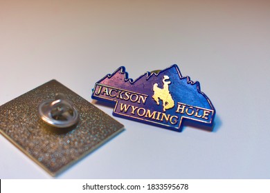 Miami, USA - October 10, 2020: Jackson Hole, Wyoming Text Logo On Plastic Blue Souvenir Pin Memorabilia With Western American Country Cowboy Riding On Horse Through The Grand Teton Mountain Landscape