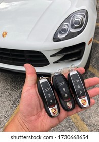 Miami, Year 2019: Three Porsche Keys In Hand. White Porsche Macan Turbo Behind. Automotive Locksmith.