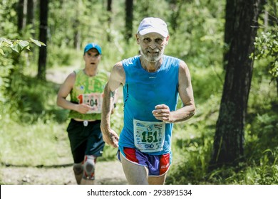 Miass, Russia - June 28, 2015: Old Man Runner Running And Smiling On Race In A Summer Forest During Marathon 