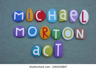 Michael Morton Act, Texas Law Text Composed With Multi Colored Stone Letters Over Green Sand