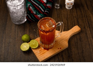 Michelada, typical mexican cocktail on a wooden table. Cocktail based on beer.