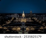 Michigan State Capitol Building in downtown Lansing at dusk with the dome lit up.  Aerial shot of the cityscape via a drone