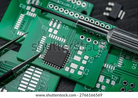 Micro chip IC on printed circuit board PCB with screwdriver and tweezers. Close-up macro shot