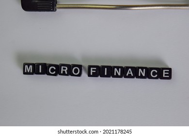 Micro Finance On Wooden Block Isolated On Table. Selective Focus On Micro Finance Text