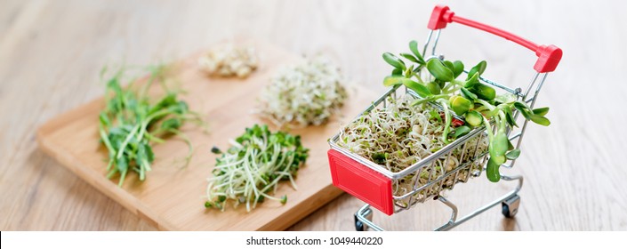 Micro Greens In Shopping Cart On Wooden Background. Different Types Of Microgreens For Sale. Healthy Eating Concept Of Fresh Garden Produce Organically Grown, Symbol Of Health. Vitamins From Nature.