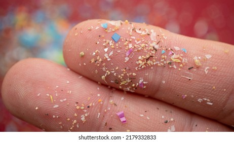 Micro Plastic Particles On A Human Finger For Scale. Concept For Water Pollution And Global Warming.