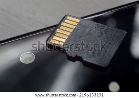 micro sd card lies on the smartphone screen. close-up