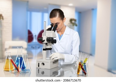 Microbiologist examining biological samples with a microscope in the laboratory.