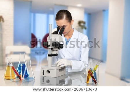 Microbiologist examining biological samples with a microscope in the laboratory.