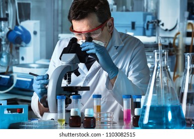 microbiologist working with sample in biomedical laboratory / microscopist analyzing samples in the microscope