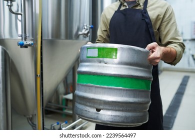 Microbrewery worker carrying heavy keg with beer, small business concept - Powered by Shutterstock