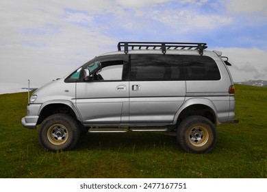 microbus, minivan with open doors Space Gear on off road in summer mountains landscape. range of trucks, multi purpose vehicles produced by Mitsubishi Motors Caucasian mountain. GOMIS MTA