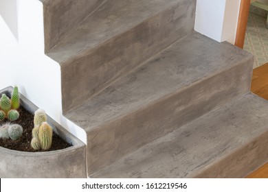 Microcement grey colour on staircase with matt finish, in combination with white walls and natural wooden floor - Shutterstock ID 1612219546