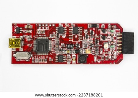 A Microcontroller programmer and debugger red PCB USB mini connection and six way female header