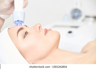 Microcurrent Light Esthetics Procedure. Beauty Girl Face. Cosmetology Machine. Doctor Hands. Two Micro Balls. Wrinkle Reduction.