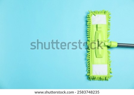Microfiber mop on light blue background, top view. Space for text