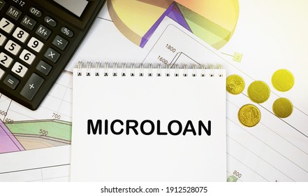 Microloan On Notepad With Calculator, Coins, Graphics On Financial Report. Business And Financial Concept