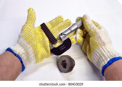 Micrometer in hands measuring small item. Isolated against white background.
