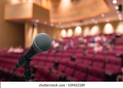 Microphone With Abstract Blurred Photo Of Conference Hall Or Meeting Room With Attendee Background