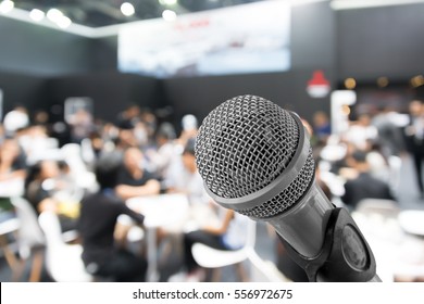 Microphone with blurred photo of conference hall or seminar room with attendee background, Business meeting concept.