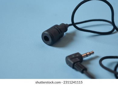 The microphone cable is black on a blue background. - Shutterstock ID 2311241115