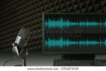Microphone and computer screen displaying audio waveforms in a recording studio setup