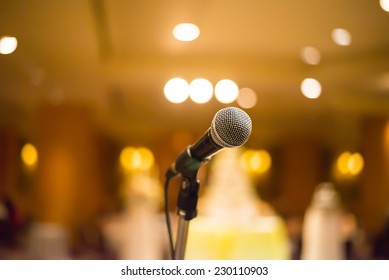 Microphone In Concert Hall Or Conference Room With Warm Lights In Background. With Extremely Shallow Dof.