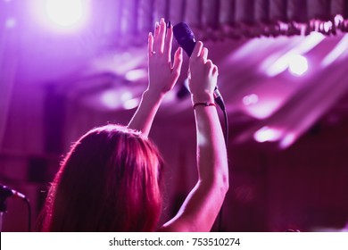 Microphone in female hands close-up.  A pub. Bar. A restaurant. Classical music. Evening. Night show. - Powered by Shutterstock