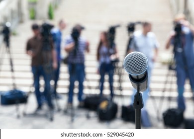 Microphone in focus against blurred camera operators and journalists. Press conference. - Shutterstock ID 529045420