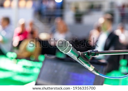 Microphone in focus against blurred people at business roundtable event