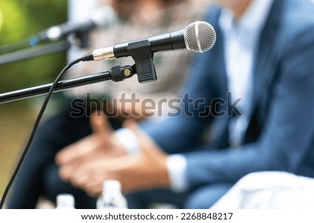 Microphone in focus at roundtable meeting or business event