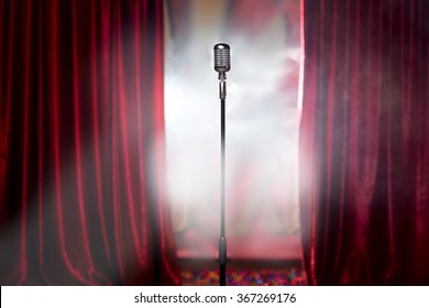 microphone in front of red curtain on an empty stage after the concert, smoke