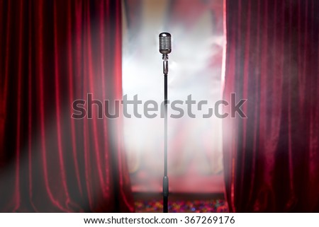 microphone in front of red curtain on an empty stage after the concert, smoke