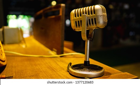 The Microphone Is Located On A Wooden Table In An Old Music Practice Room.