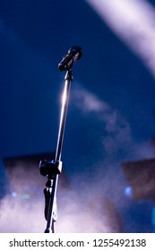 Microphone in nighttime outdoor concert, artificial lighting.