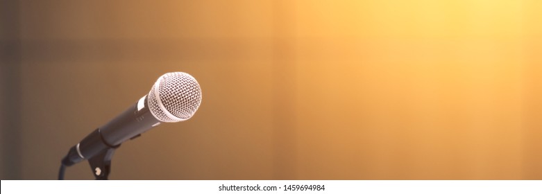 Microphone on abstract blurred of speech in seminar room or speaking conference hall light