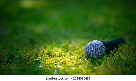 Microphone on a green summer background. An outdoor concert. Performance in nature. - Powered by Shutterstock