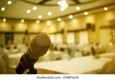 Microphone on podium with abstract blurred of conference hall or seminar room event background, vintage tone