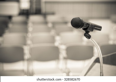Microphone on the speech podium over the Abstract blurred photo of conference hall or seminar room background