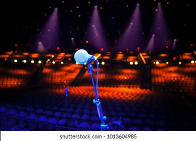 Microphone On Stage Overlooking A Large Empty Concert Venue - Show Cancellation Or Stage Fright Concept