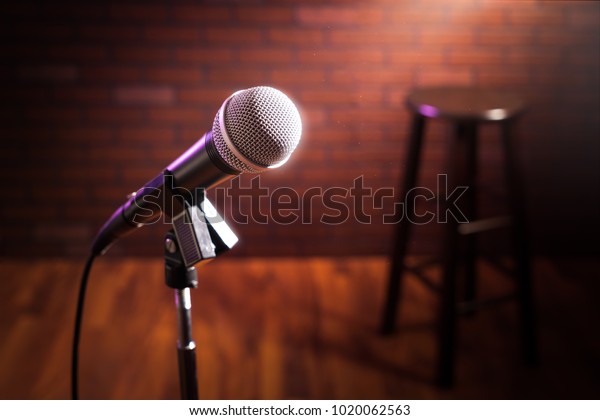 microphone on a stand up comedy stage with\
reflectors ray, high contrast\
image