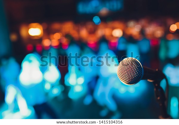 microphone on a stand up comedy stage with\
colorful bokeh , high contrast\
image.